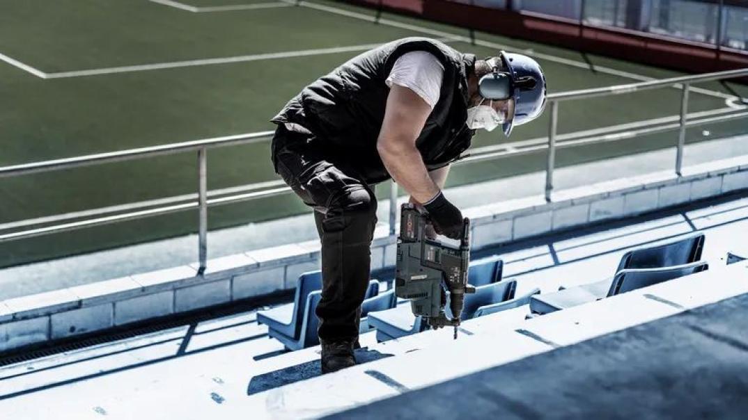 Professionista in cantiere usa punta Bosch SDS plus per forare cemento