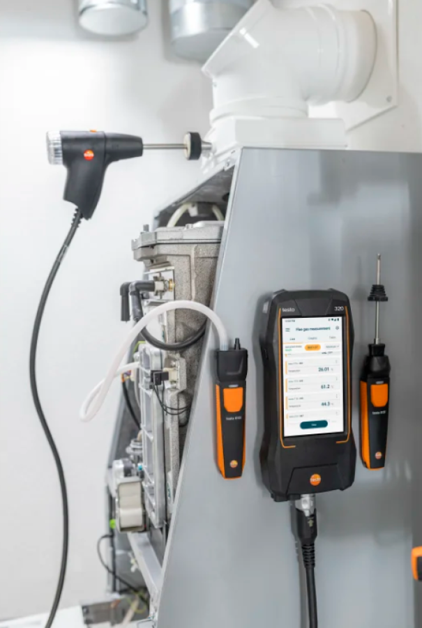 Testo 320 analizzatore e sonde installati su caldaia durante la manutenzione di sistemi di combustione