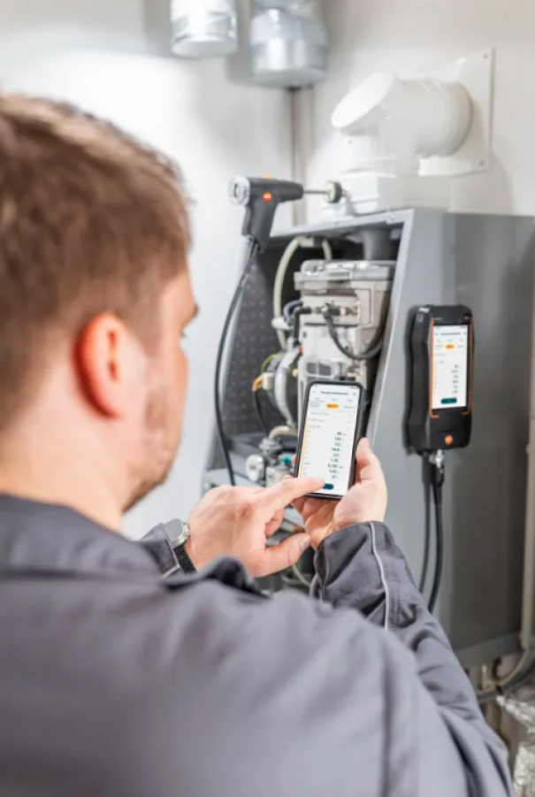 Operatore verifica i dati tramite app sincronizzata analizzatore combustione Testo 320 su impianto